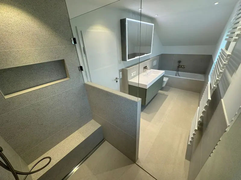 Badezimmer mit Dusche, Sitzbank, Glaswand und Waschtisch