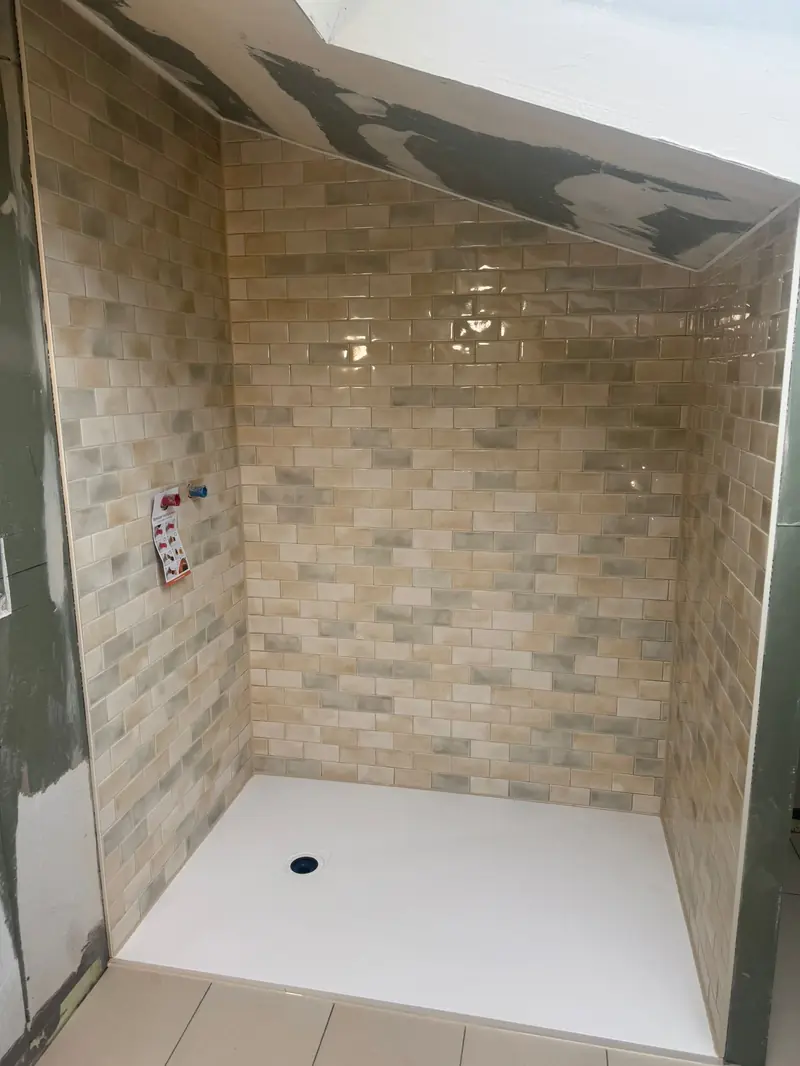 Dusche in der Dachschräge mit glasierten Wandfliesen im Ziegelverband