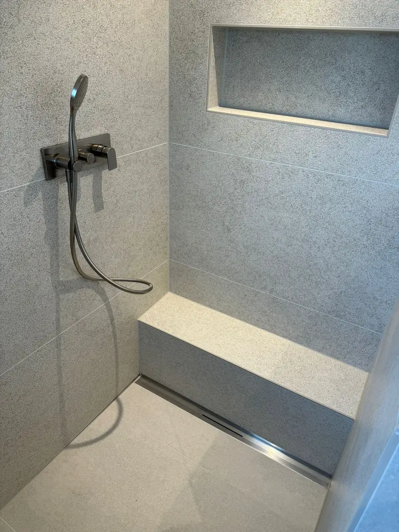 Dusche mit Sitzbank, Duschnische und großformatigen Fliesen